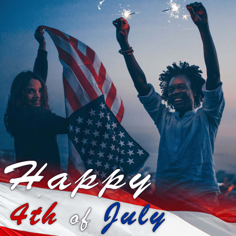 Two friends celebrate the 4th of July, waving an American flag as sparks fly at dusk.