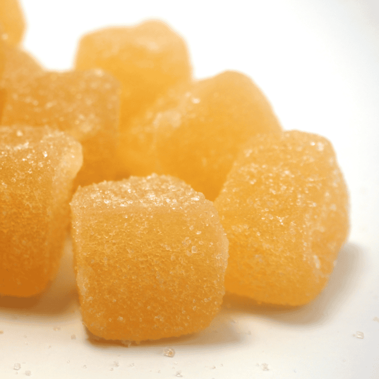 Close-up of several brown sugar cubes piled on a white surface/plate.